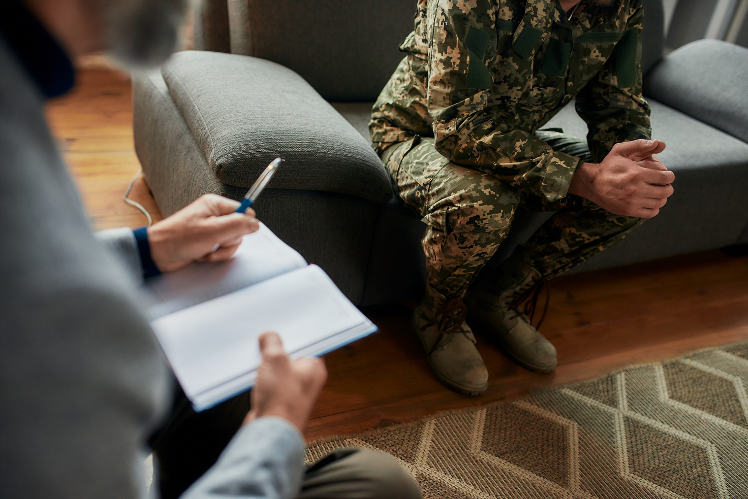 Cropped shot of military man during therapy session with psychologist. Soldier suffering from depression, psychological trauma. PTSD concept